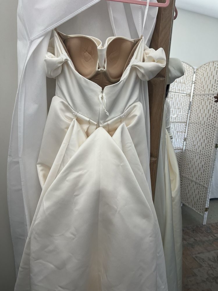 A finished French bustle, the train gathered into folded points and buttoned up at the back of the gown