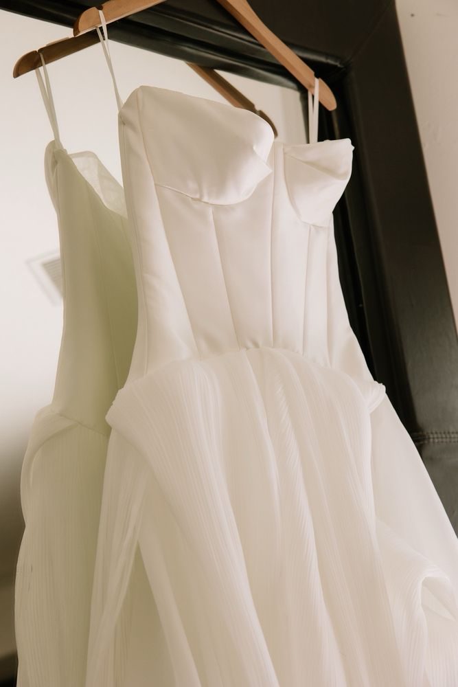 A structured wedding dress bodice on a hanger showing the boning and seams inside