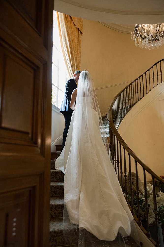 A gown and veil arranged down a curving staircase